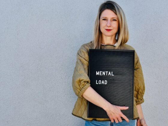 Laura Fröhlich hält ein Schild mit der Aufschrift mental load